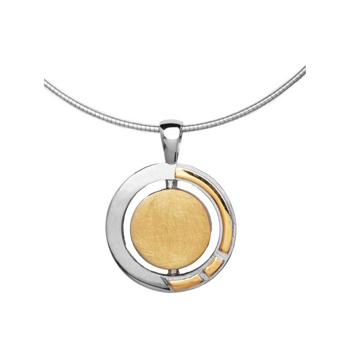 A necklace featuring the Urú Large Pendant & Chain with a modern Celtic pendant with a circular design. The pendant combines sterling silver & gold vermeil, with a gold central disc and a partially encircling silver frame, accented by small gold details. This elegant piece by Gallardo & Blaine Designs hangs from a sleek, silver chain.