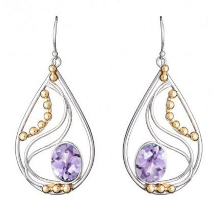 A pair of Phoenix Earrings in various gemstones by Gallardo & Blaine Designs featuring a silver frame with swirling designs. These elegant drop earrings have small gold beads along the curves and each showcases a large, faceted lavender gemstone at the bottom center.