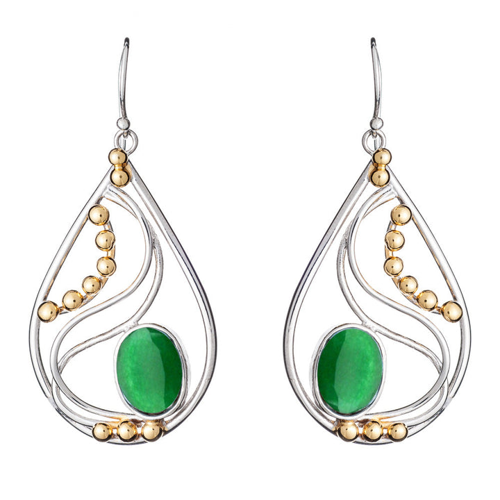 The Phoenix Earrings in various gemstones by Gallardo & Blaine Designs are a pair of elegant drop earrings featuring silver frames with decorative gold beads. Each earring showcases a large oval green stone set in the center, surrounded by intricate silver curves. These sophisticated silver and gold earrings hang gracefully from simple hooks.