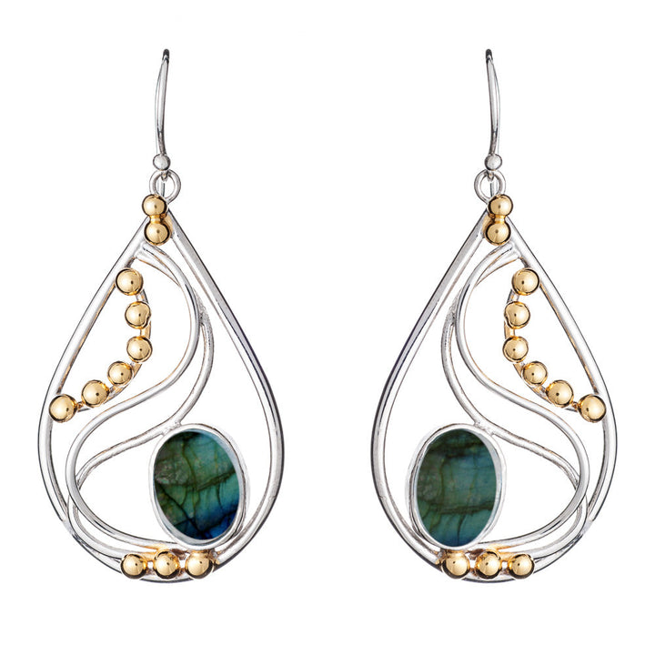The Phoenix Earrings in various gemstones by Gallardo & Blaine Designs are an elegant drop design featuring a blend of silver and gold tones. Each earring showcases a greenish-blue oval stone at the center, framed by delicate gold beads arranged in graceful curves. Complete with fishhook backings, these earrings exude timeless elegance.
