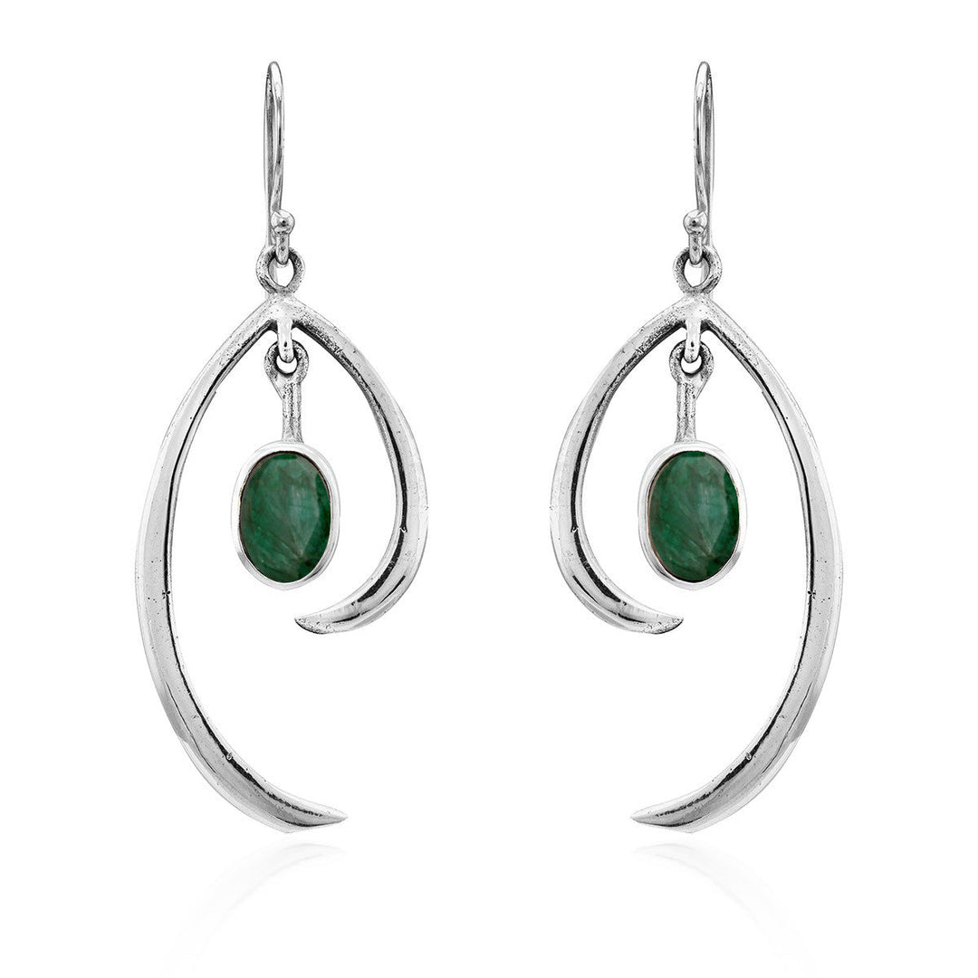 Discover the Primrose Earrings in various gemstones by Gallardo & Blaine Designs, a pair of sterling silver earrings that exude minimalist elegance. These silver drop earrings feature an abstract curved design with an oval green stone hanging in the center, all suspended from simple hooks.