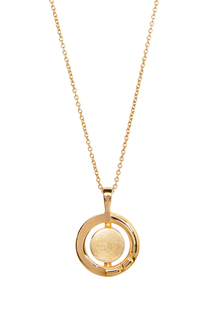 A gold Urú Small Pendant & Chain by Gallardo & Blaine Designs features a delicate chain and a circular pendant. The pendant consists of a large, brushed gold disc encircled by an open, polished gold ring. Drawing inspiration from Celtic tradition, the design is modern and minimalist.