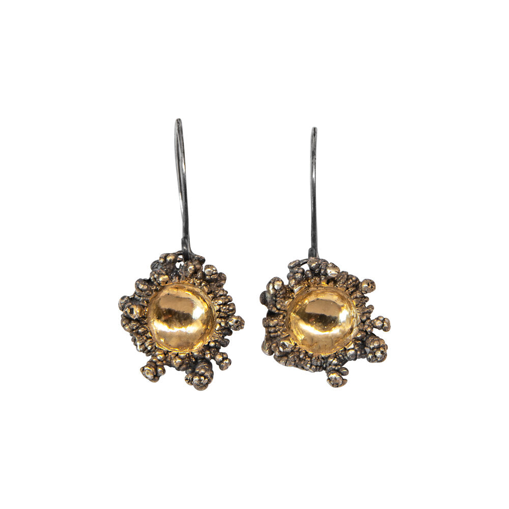 The Abbie Dixon Spore Drops Black & Gold Earrings feature round, textured bubble-like designs around a shiny gold center, with simple wire hooks, shown on a white background.