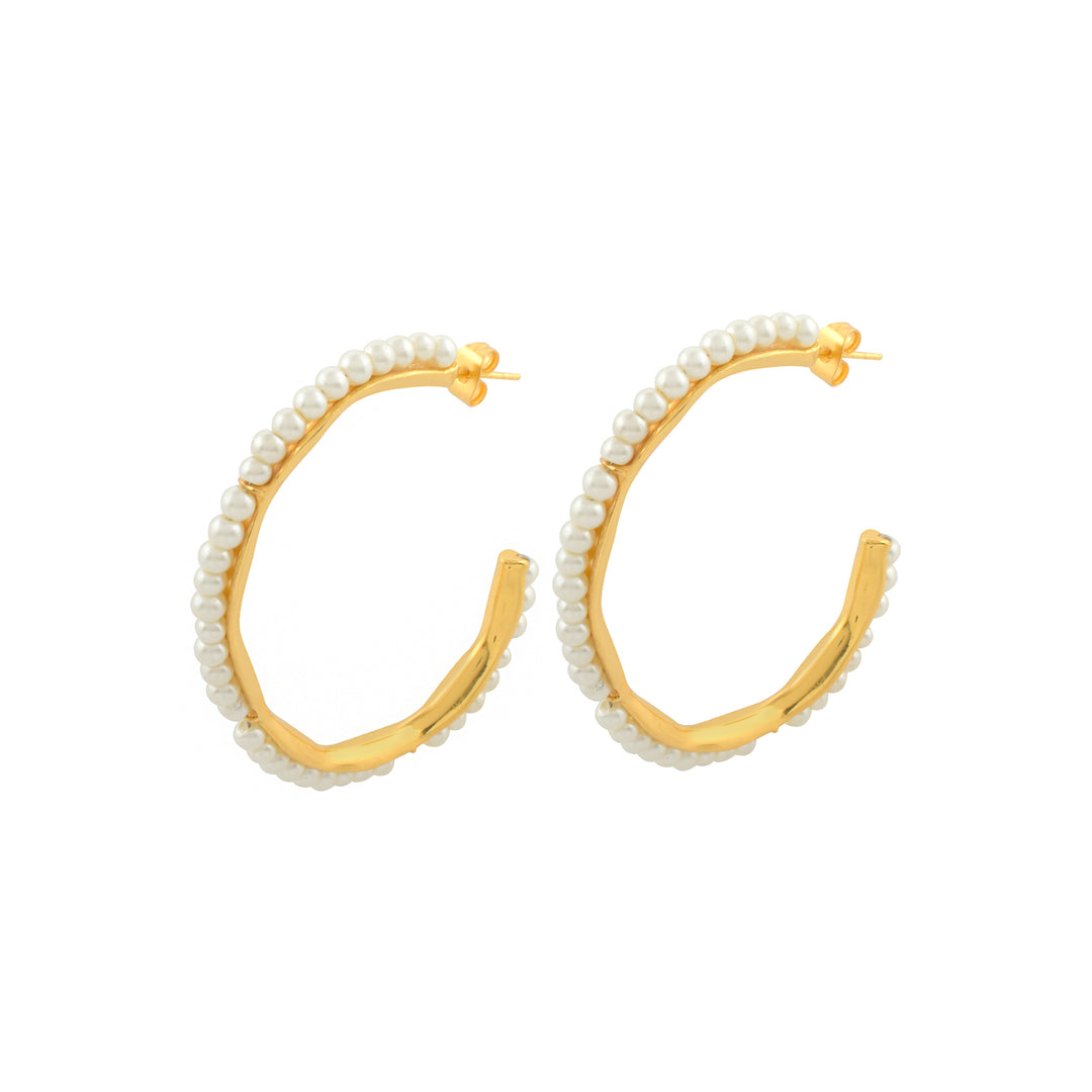 A pair of Hermanie Pearl Earrings with a unique, slightly irregular shape. Crafted from 19 carat gold, these stunning pieces are adorned with small white pearls along the outer edges. Designed as hypoallergenic jewelry, they have post back closures. Shyla brings you elegance and style in every detail.