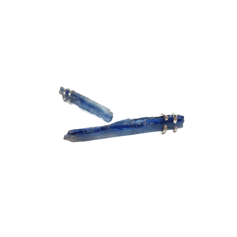 Two unique Caroline Stokesberry-lee Raw Kyanite Shard Earrings, each featuring a blue crystal point secured by sterling silver clasps, are displayed against a white background.