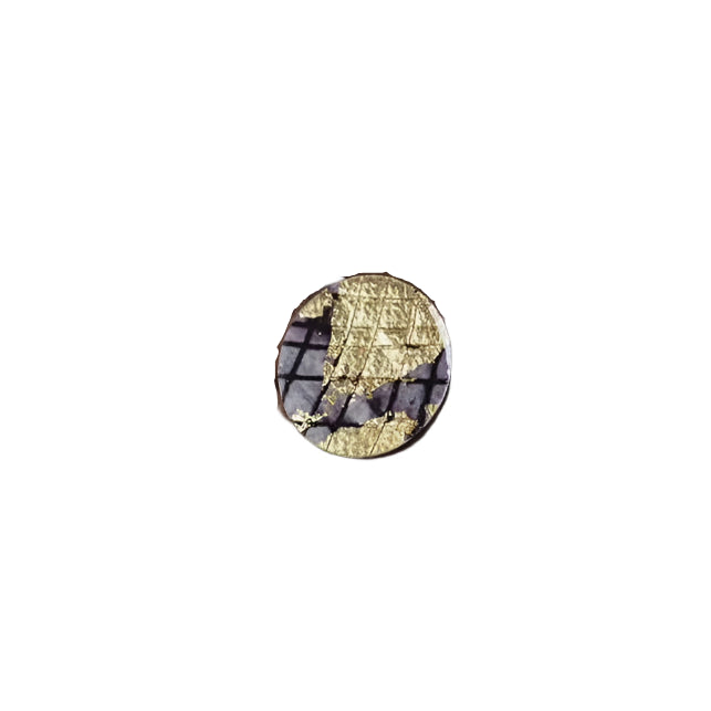 The Ró Cocktail Ring in Gold/Black by Rothlú features a small, round design with a textured gold sgraffito batik pattern over a dark, grid-like background, displayed on a white surface.