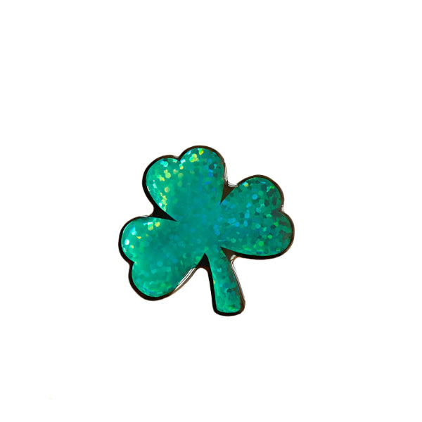 The Naoi Shamrock Pin Brooch features a shiny green glittery three-leaf design on a white background.