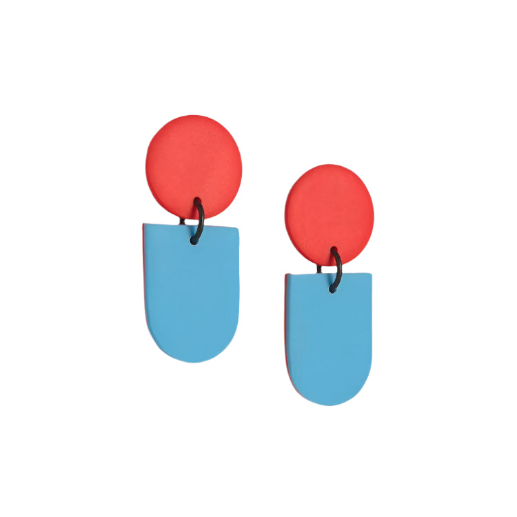 The Tengae Red & Robin's Egg Earrings by Culu Design are modern dangle earrings, featuring a red circular top and a blue rounded rectangular bottom linked with a black loop. Handmade from polymer clay, they’re shown on a white background.