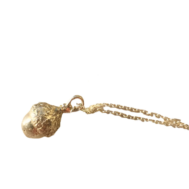 The Little Acorn Necklace Silver by Andrea Mears Jewellery features a textured, irregularly shaped silver pendant, reminiscent of an acorn and a subtle symbol of wisdom, shown isolated on a white background.