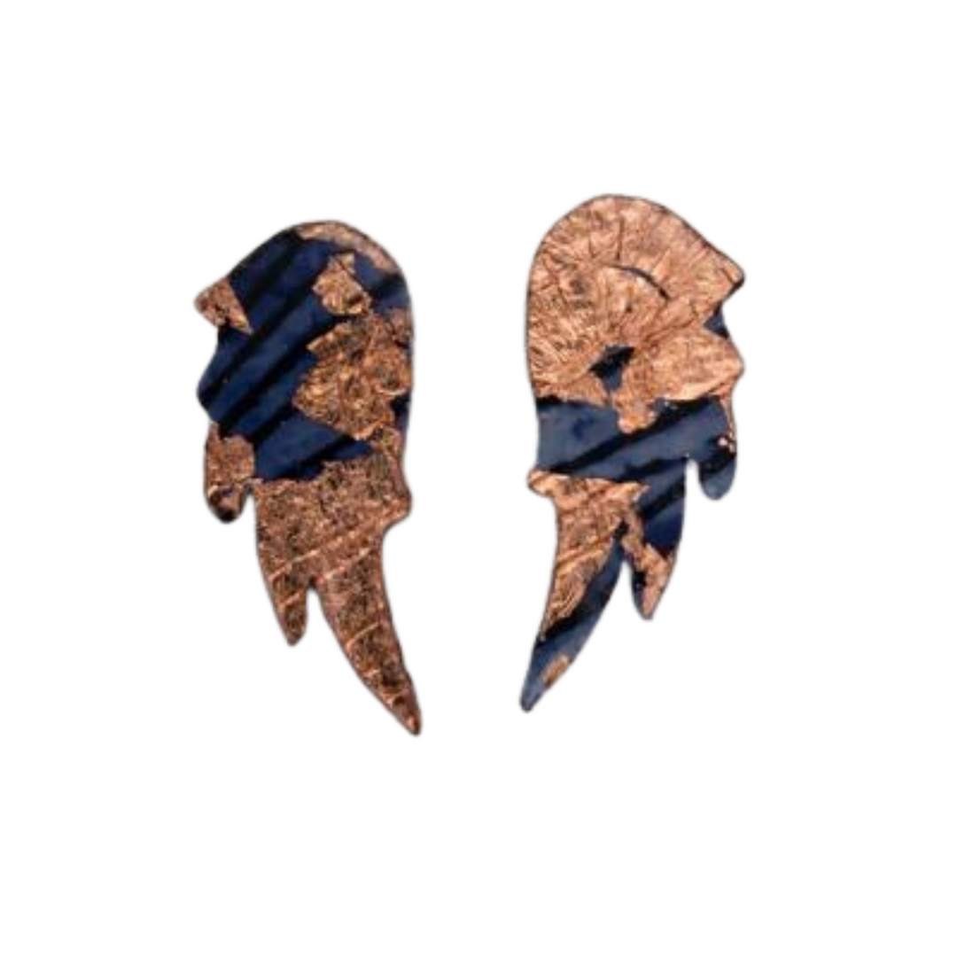 A pair of abstract wing-shaped Wings of Desire Sgraffito Stud Earrings by Rothlú featuring a mix of dark blue and gold textures on a white background. The earrings have an uneven, organic shape with sterling silver posts and a metallic finish that highlights intricate details.