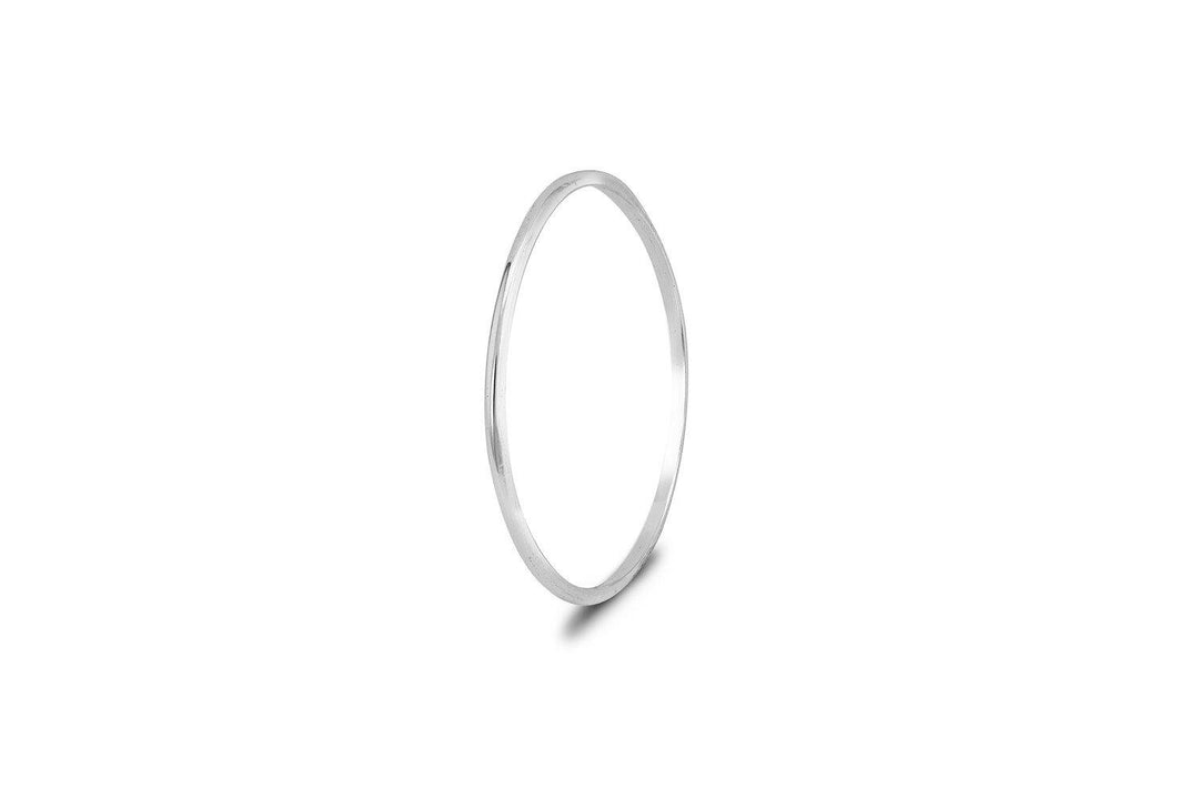 A simple, thin sterling silver bangle with a smooth, polished finish. The handmade Cosmic Thread Stacking Ring Sterling Silver by Cosmic Boulevard is circular and minimalistic, casting a faint shadow on a plain white background.
