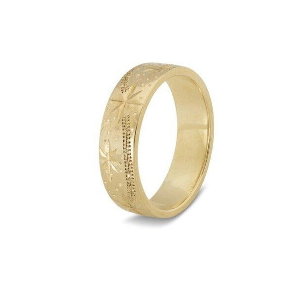 A yellow gold ring with a smooth, polished finish and engraved shooting star patterns around the band. The design is intricate and detailed, giving the Shooting Stars 9ct Yellow Gold Ring by Cosmic Boulevard an elegant and sophisticated appearance. The background is plain white.