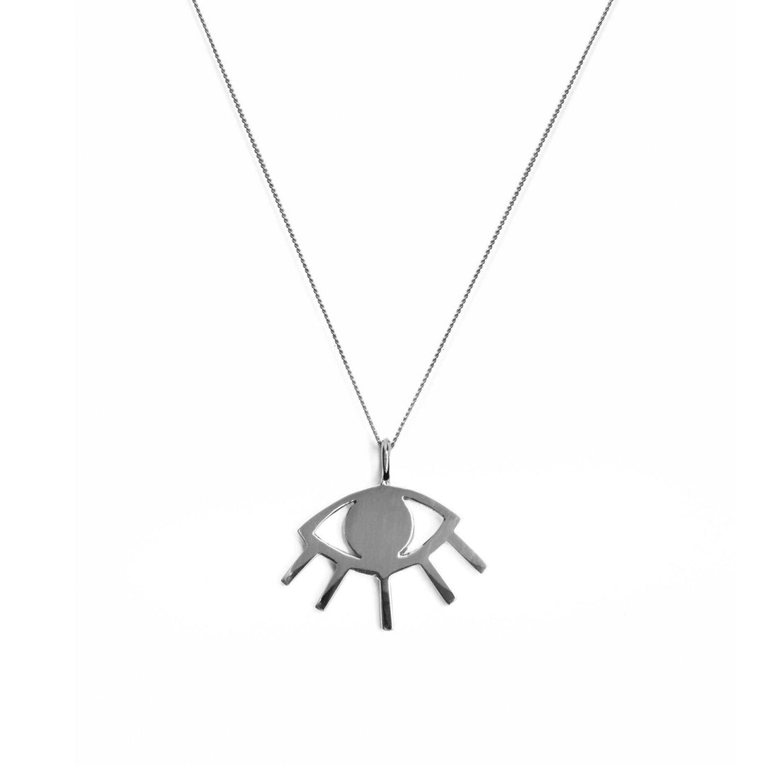 A **Silver Evil Eye Pendant** by **Cosmic Boulevard**. The central oval represents the iris, with radiating lines resembling eyelashes, creating the appearance of an elegant talisman. The delicate chain adds a refined touch to this evil eye necklace against a plain white background.