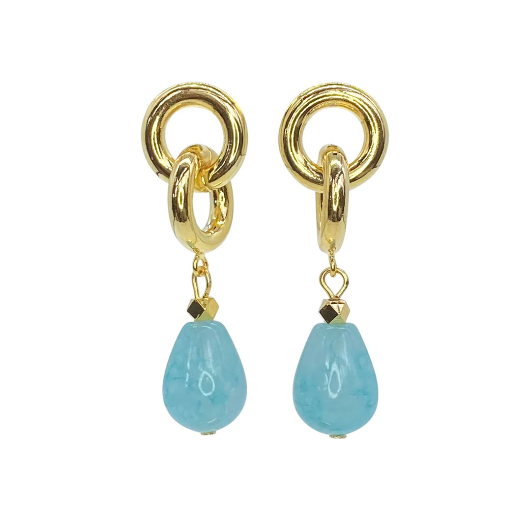 Introducing the Eternity Earrings by Aria V: Gold earrings featuring circular loops with blue amazonite teardrop-shaped gemstones hanging from them. Handmade in Dublin, the design includes an additional small gold bead above each gemstone. These earrings combine a touch of elegance with vibrant blue accents.