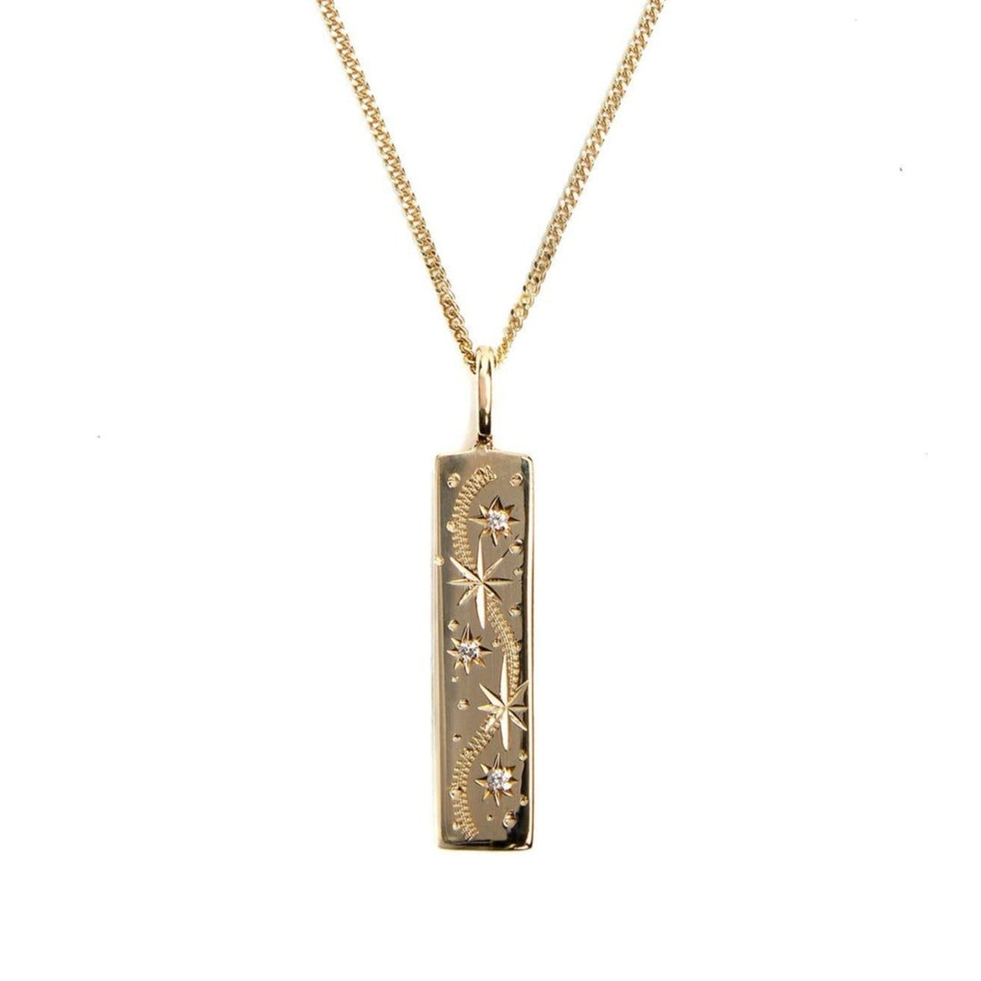A gold rectangular pendant with delicate star designs and small embedded crystals is suspended from a fine yellow gold chain. This piece of handmade jewellery features engravings of stars connected by a dotted constellation pattern, giving it a celestial-themed appearance. This unique piece is the Oh my Diamond Stars 9ct Yellow Gold Necklace by Cosmic Boulevard.