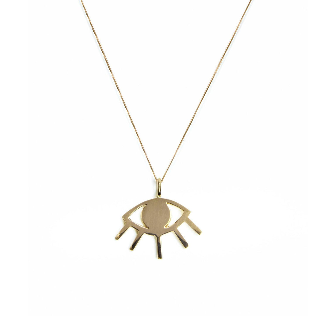 The Cosmic Boulevard 9ct Gold Evil Eye Pendant, crafted in yellow and rose gold, features a talisman pendant shaped like an abstract evil eye. The gold pendant consists of an oval center surrounded by an angular outline with small protruding lines resembling eyelashes. It hangs from a thin, gold chain against a plain white background.