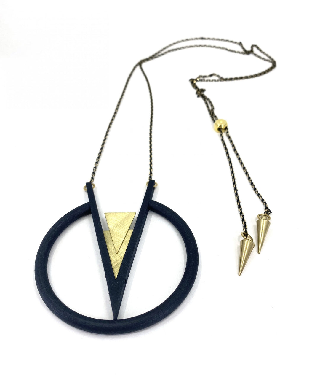 The Elsiem Vibe Pendulum Necklace features a bold geometric design with a thin black and gold chain, a large black circle, inverted V shape, gold triangle, and two gold cone pendants.