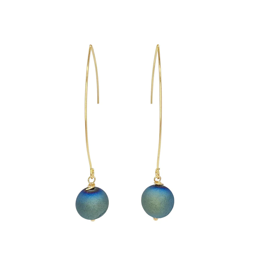 The Ali Earrings by Aria V are delicate 16k gold plated hook earrings, adorned with round, blue-green beads hanging at the ends. These handcrafted earrings feature a minimalist design with a smooth and slightly curved gold wire that accentuates the simplicity and elegance of the dangling beads.