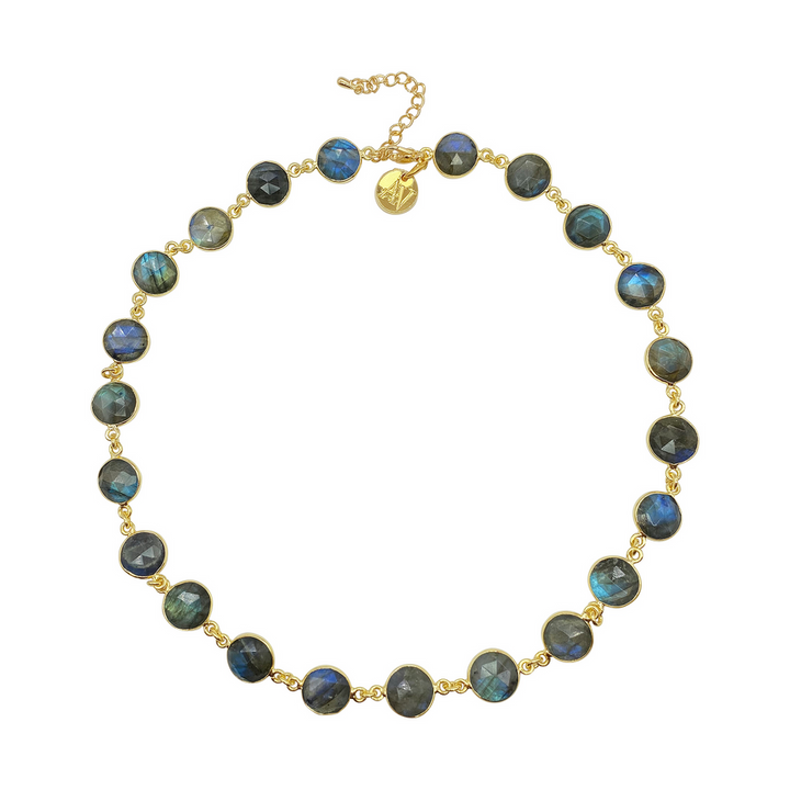 A handmade Aria V Aurora Necklace featuring round labradorite gemstones, each set in a gold bezel and linked together. The necklace has an adjustable gold chain with a small charm near the clasp. The iridescent labradorite stones shimmer in shades of blue, green, and grey.