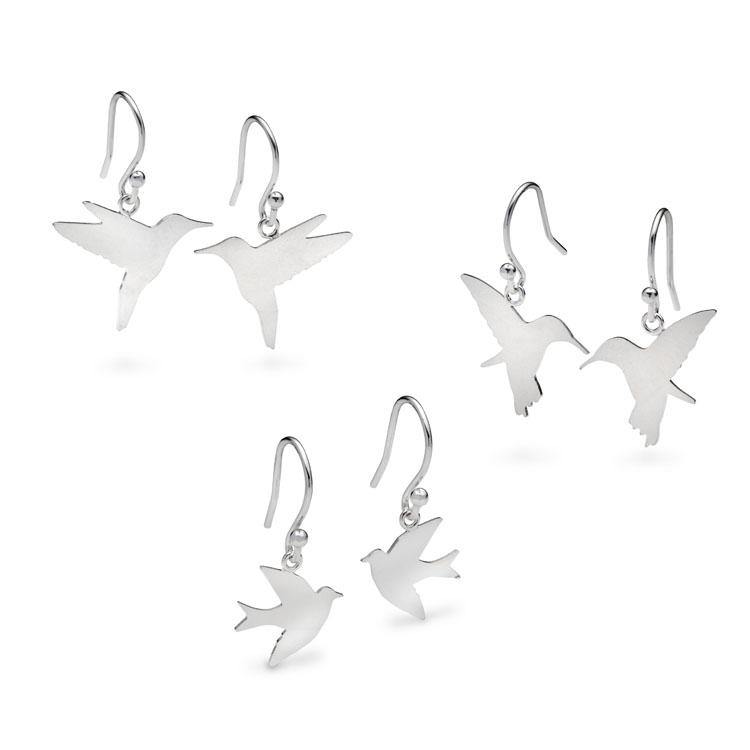 A set of three pairs of sterling silver Bird Drop Earrings Silver by Leoma Drew featuring different bird silhouettes. Each pair has a simple hook for wearing, with one pair resembling a hummingbird, another a swallow, and the third pair a sparrow, all shining with a smooth, polished finish.