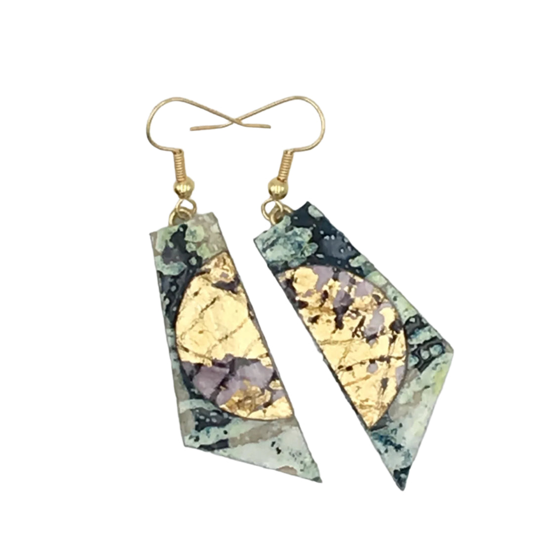 A pair of Rothlú Cora Batik Textile Earrings in Dark Green/Gold/Aubergine with hypo-allergenic gold plated hooks, featuring a unique textured abstract design in shades of gold, black, white, and soft green. Each earring boasts a gold foil semicircle and an irregular diamond shape with a multicolored pattern in the background.