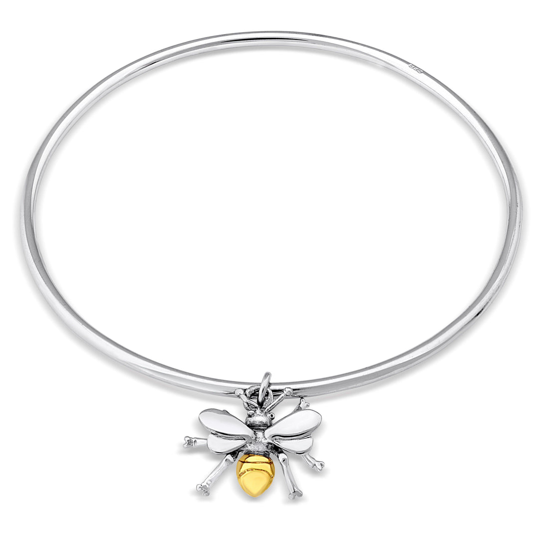 A Gallardo & Blaine Designs Wildlife Bee Bangle Silver & Gold featuring a charm in the shape of a honey bee. The bee charm has a yellow, enamel-coated body, silver wings and legs. The charm is attached to the bangle at the top, with the bee hanging down.