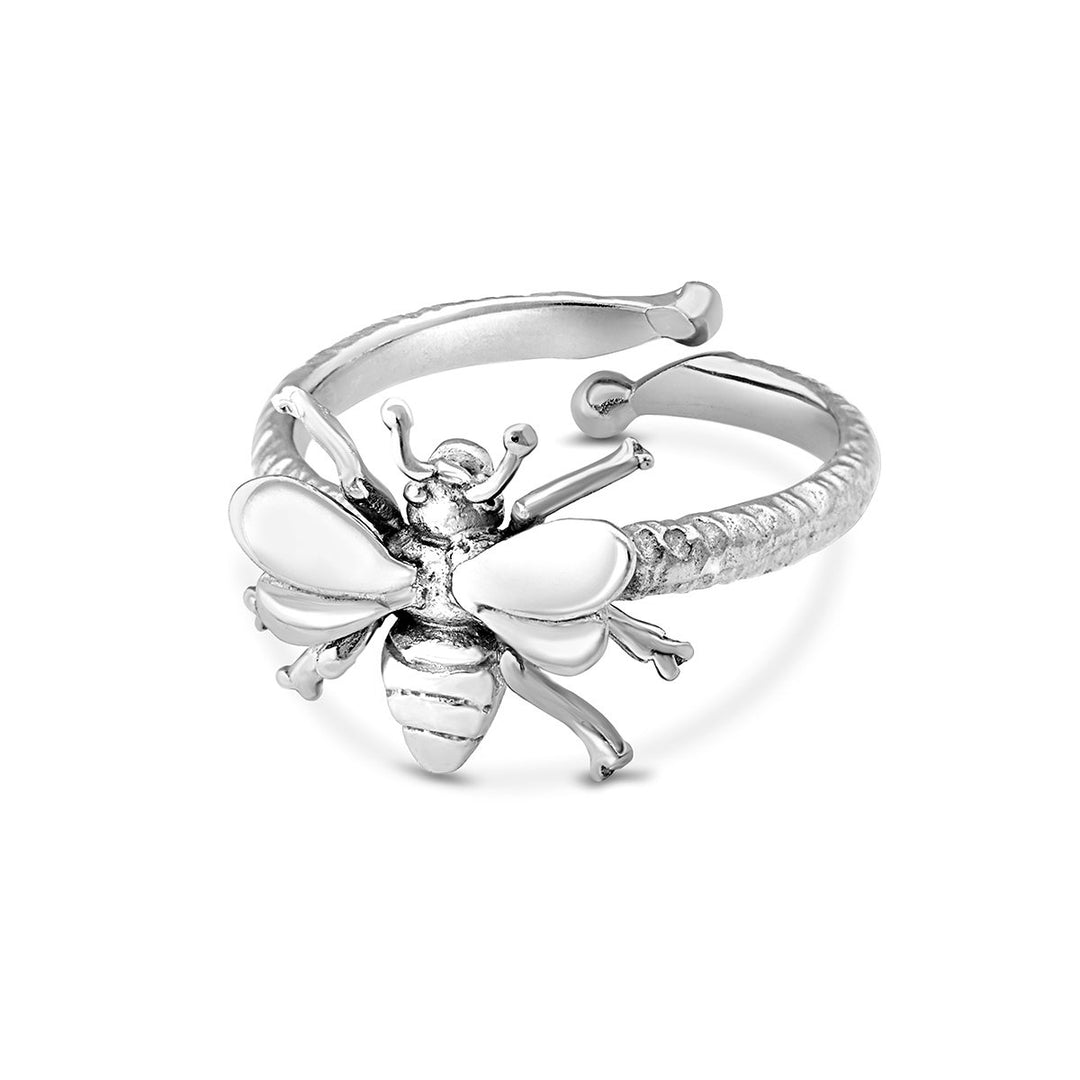 A close-up of an adjustable sterling silver bee ring, the Wildlife Bee Ring Silver by Gallardo & Blaine Designs, featuring an ornate bee design with intricate details. The textured band adds to the overall elegance, while the slightly raised wings give a three-dimensional appearance. Part of our Wildlife Collection, this piece subtly echoes the "Save the Bees" message.