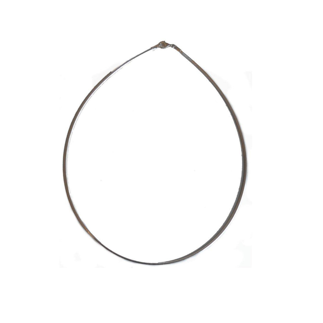 A product from The Collective Dublin called the Silver Flexi Choker forms a circle, used to secure objects together. The choker is shown against a plain white background, creating a contrast that highlights its coiled, flexible nature, much like an 18" Sterling Silver chain in its elegance and simplicity.