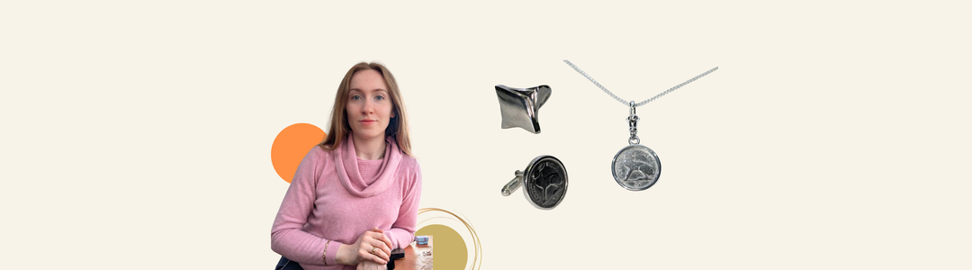 A woman in a pink sweater sits beside three pieces of silver jewelry: a ring, a pendant necklace with a coin, and a modern sculptural ring, all on a light background with orange and yellow circles.