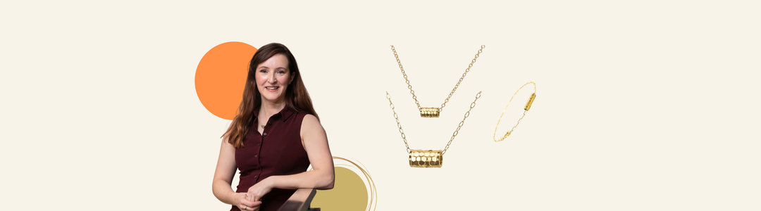 A woman with long brown hair, wearing a sleeveless maroon top, stands with her hands clasped. The background features text about Andrea Mears, a jewelry designer inspired by myths, nostalgia, nature, and positivity, based in Limerick.