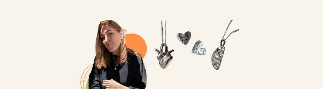 A woman with light brown hair poses smiling next to four silver heart-shaped necklaces against a beige background with orange and tan abstract shapes.