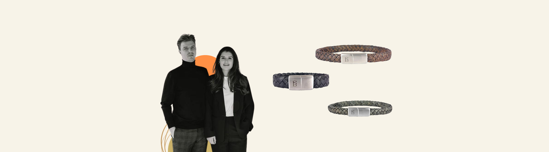 A man and woman stand together, both dressed in black and white, next to three braided bracelets in brown, navy, and green, each with a metal clasp, displayed on a light background.