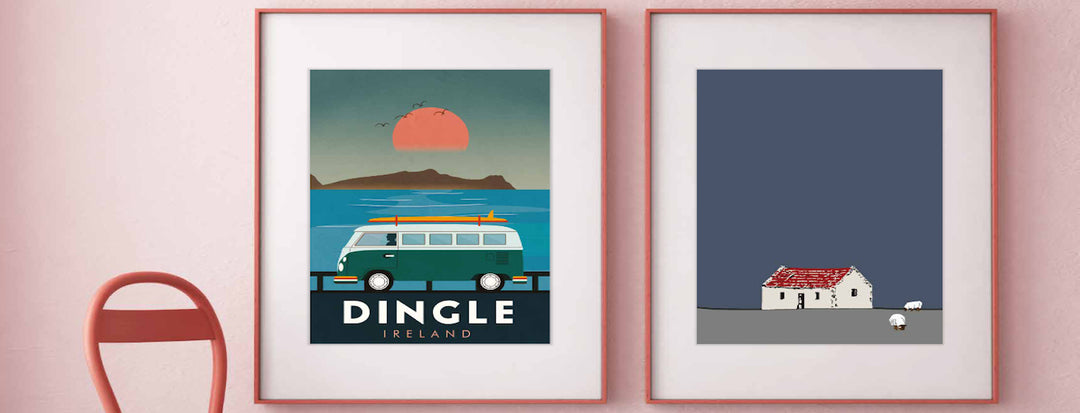 Two framed art prints hang on a pink wall. One shows a van by the sea with "Dingle Ireland," the other depicts a small white cottage and sheep on a gray field with a dark blue sky.