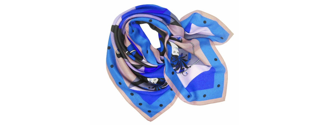 A vibrant blue and purple silk scarf with a geometric design and black polka dots along the border, elegantly folded with various colors and patterns visible.