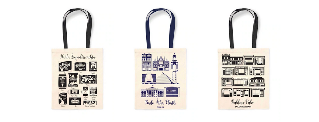 Three tote bags displayed side by side. The first bag features Irish Superbrands designs, the second Dublin landmarks in blue, and the third various Dublin pubs in black. All bags have black handles and white background.