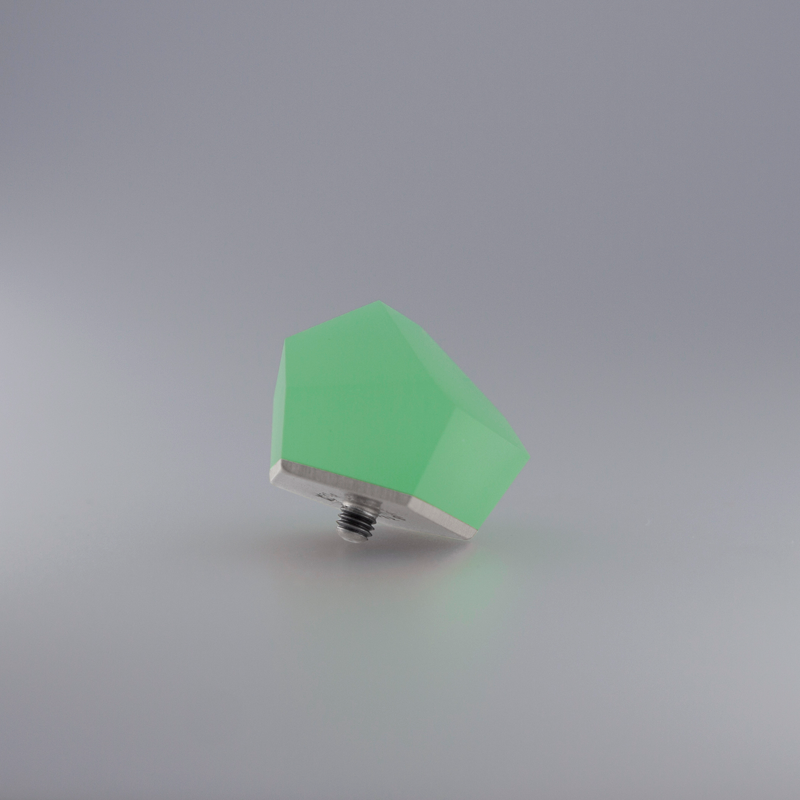 A Fruit Bijoux Fruit Bijoux Ring Top VU Crystals Flash Green with a sterling silver base and screw-like attachment, set against a plain, light gray background. The object appears to have a smooth, faceted surface and is slightly tilted.