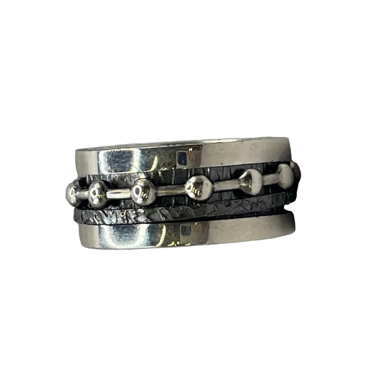 The Silver Double Spinner Ring with Balls by K.And features a textured black center band accented with small silver beads for added elegance.