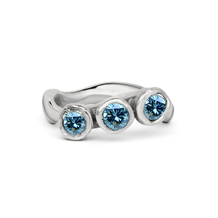 The Moonwater Ring by Madeleine Sculptural Jewellery features three round blue stones set in a modern, slightly wavy silver band—a stunning, sustainable addition to any jewellery collection.