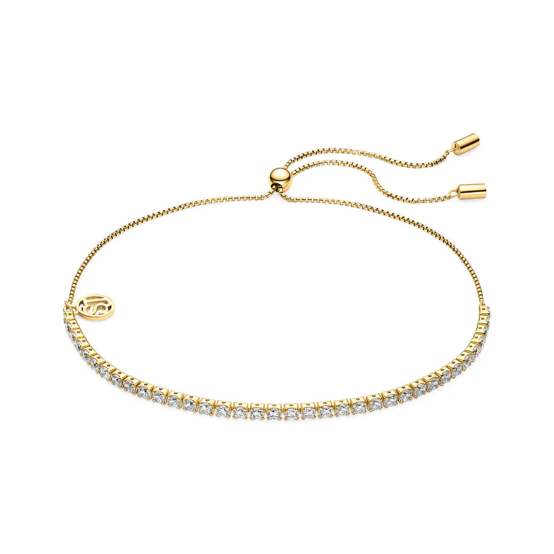 The Sif Jacobs Ellera Tennis Bracelet Gold features a delicate gold-plated design with sparkling clear stones, an adjustable slider clasp, and a small round charm at one end.