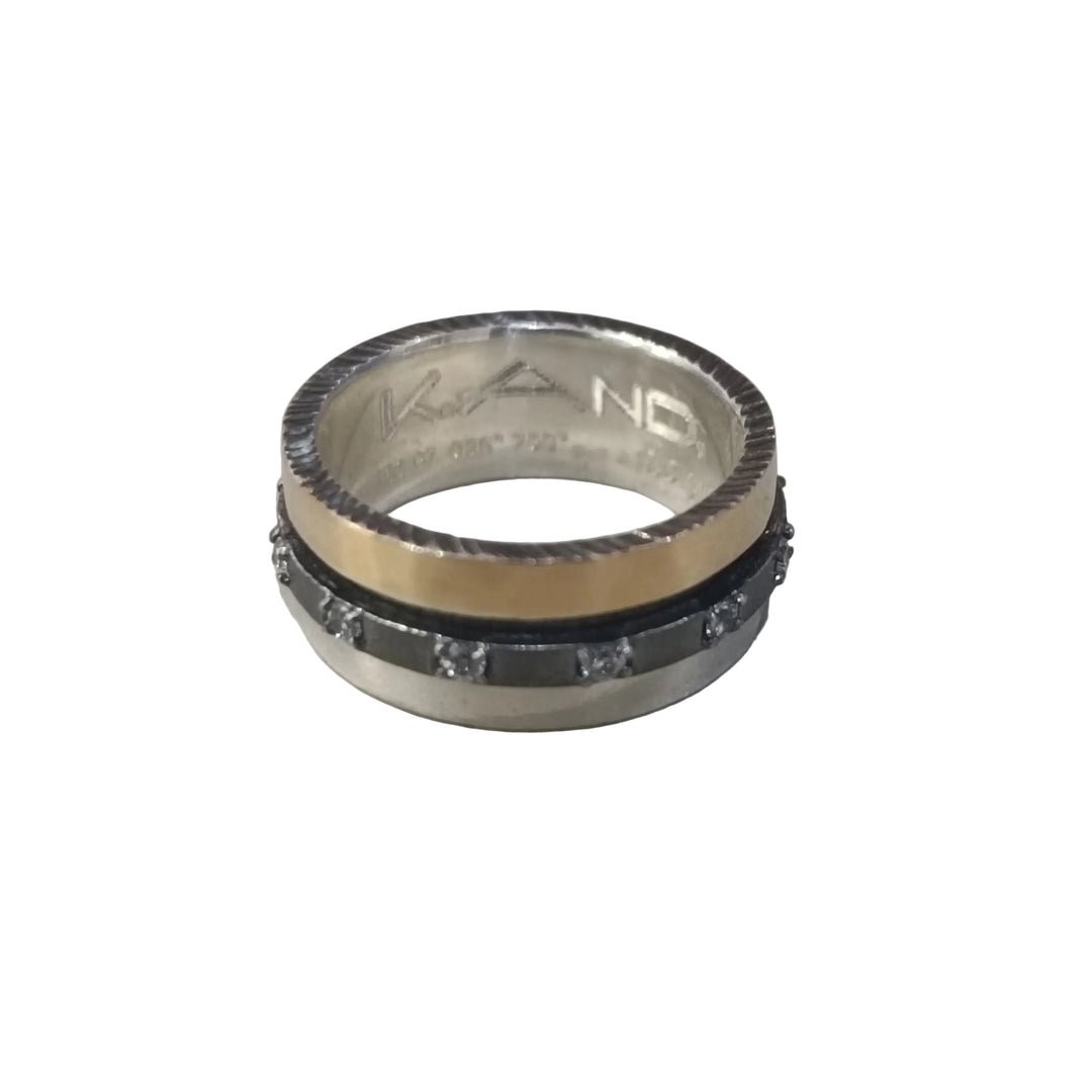 The K.And Spinner Ring in Silver & 18ct Yellow Gold with CZ features a gold-toned edge, black center band, sparkling cubic zirconia stones, and an engraved message inside.