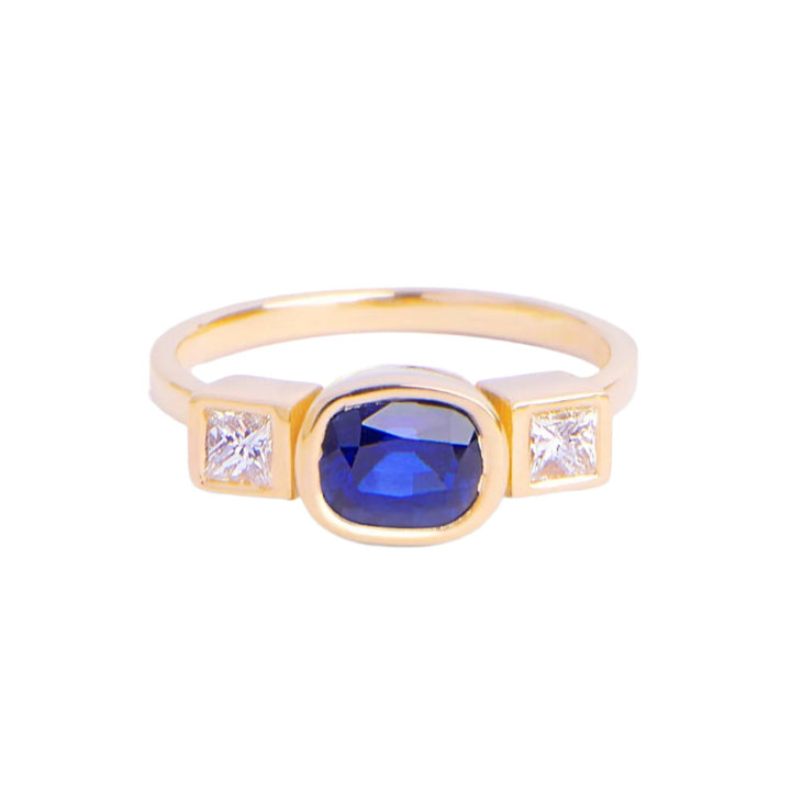 18ct yellow gold ring round sapphire in centre set in 18ct gold with square diamond on either side. Band is 1.75 mm wide