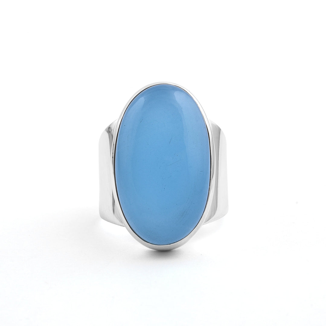 A Watermelon Tropical Aqua Chalcedony Sterling Silver Band with a large, polished, oval-shaped aqua chalcedony stone set in the center. The plain white background highlights the band’s smooth surface and simple yet elegant design.