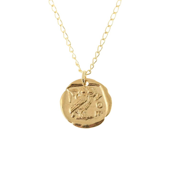 A gold plated necklace with a pendant featuring an engraved owl and some Greek letters. The round, slightly irregular pendant mimics an Athena Coin Necklace Gold by Andrea Mears Jewellery, giving it a vintage look and rich symbolism as it hangs from a delicate gold chain.