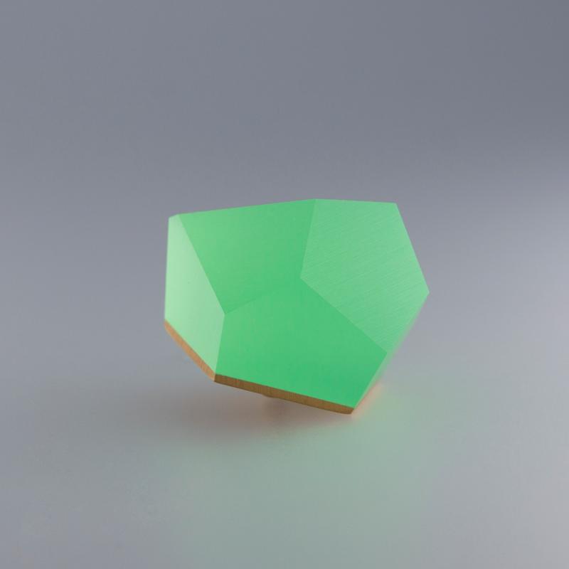 A 3D geometric shape resembling a pentagon is shown against a gray background. The shape has a bright green color with a gradient that shifts to a lighter hue, creating a soft glow effect reminiscent of sterling silver. The lighting emphasizes its edges and smooth surfaces, similar to the Fruit Bijoux Ring Top VU Crystals Flash Green by Fruit Bijoux.