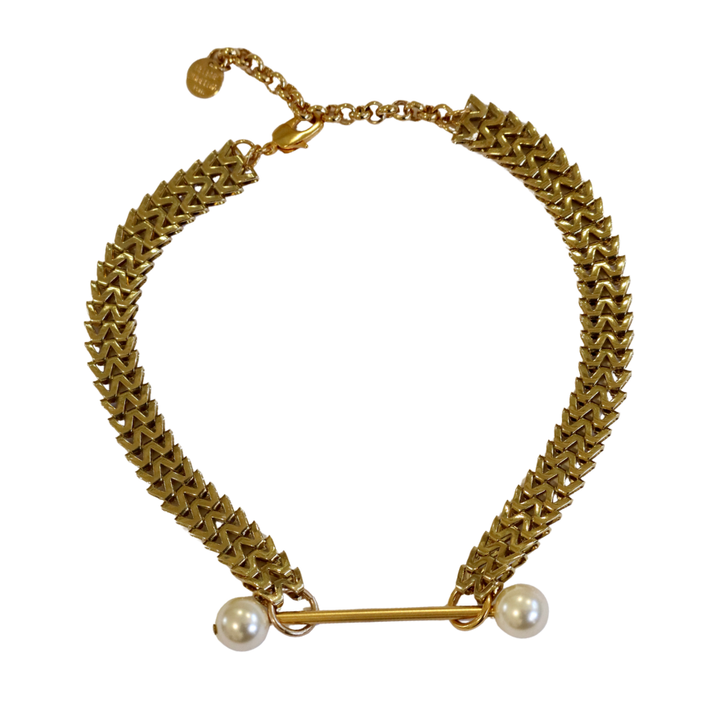 The Zubeldia Gold Bar and Double Pearl choker features a textured gold-plated chunky chain, a bar with white pearls on each end, an adjustable clasp, and a small charm for an elegant statement.