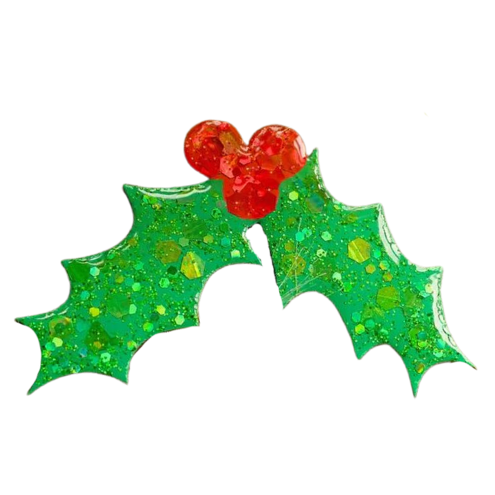 The Naoi Holly Pin Brooch is a glittery resin accessory with two green holly leaves and three red berries on a white background—ideal as a handpainted holiday accent.