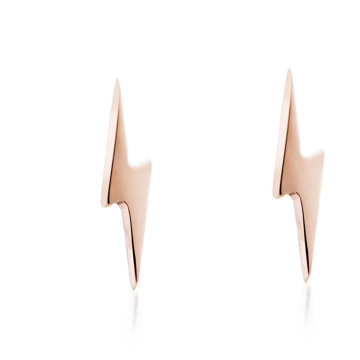 A pair of minimalist, rose gold Tiny Lightning Bolts 9ct Gold from Cosmic Boulevard set against a white background. These handmade jewelry pieces have a sleek, polished finish and simple yet striking design.