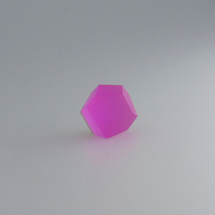 A 3D rendering of a pink, semi-transparent hexagonal gemstone with smooth edges, set against a plain, light gray background. The stone appears to be slightly luminous, giving off a soft glow. Envision this beautiful gem as the Fruit Bijoux Ring Top VU Crystals Magenta Pink on an elegant piece with sterling silver accents.