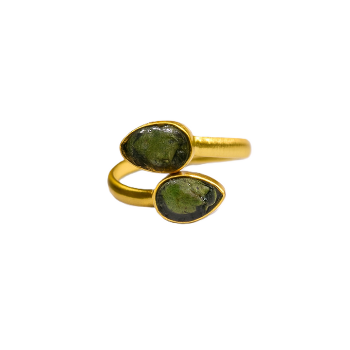 The Celia Gold Rough Emerald Ring by Watermelon tropical features an open design with two teardrop-shaped dark green stones on each end, beautifully displayed against a white background.