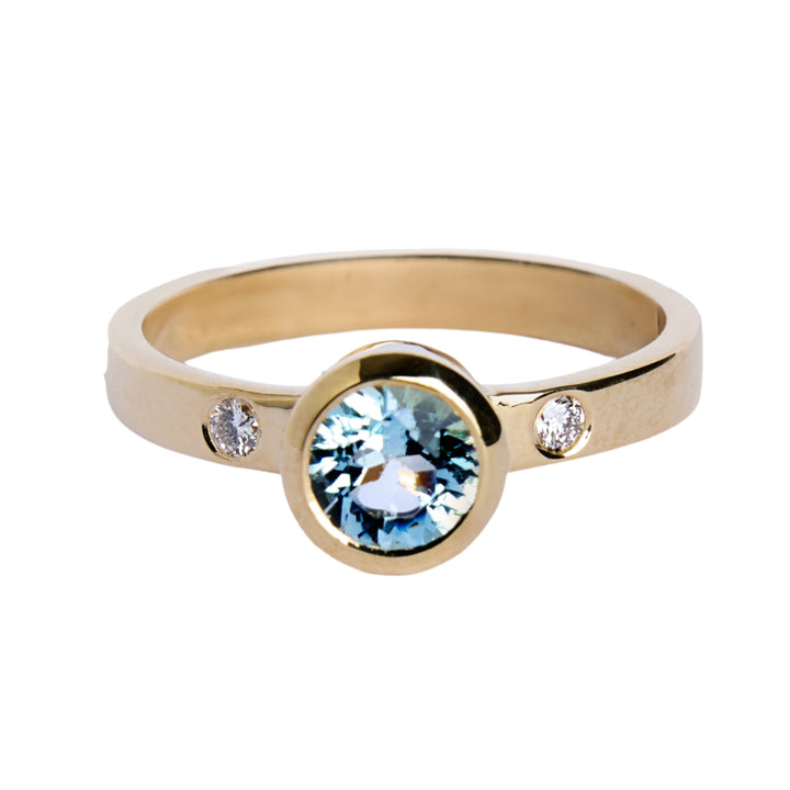 9ct yellow gold ring with aquamarine in gold bezel with small inlaid diamond on either side. Band is flat and 3mm in width.